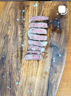 Aged steak slices presented on a marbled wood board