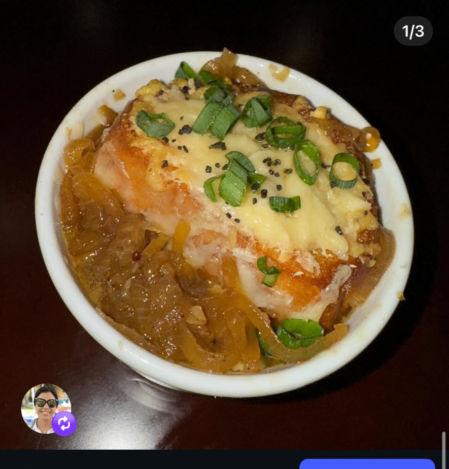 French onion soup baked with melted cheese and scallions
