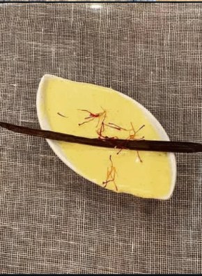 Saffron vanilla custard plated on a leaf-shaped dish
