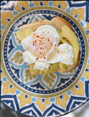 Poached eggs over avocado toast on a patterned plate