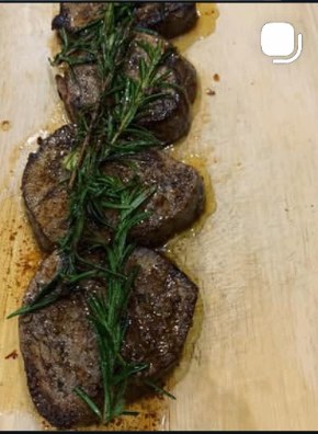 Rosemary lamb medallions seared on a wooden board