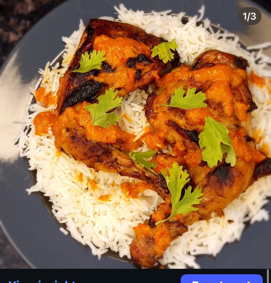Peri peri chicken over basmati rice with bright orange sauce
