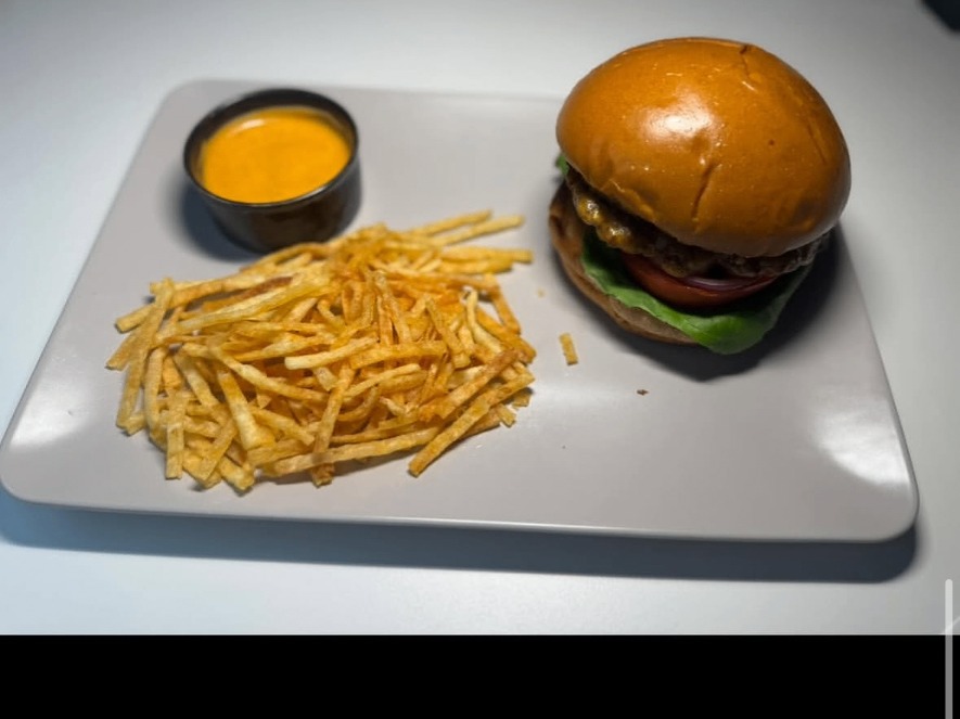 Burger and shoestring fries served with dipping sauce