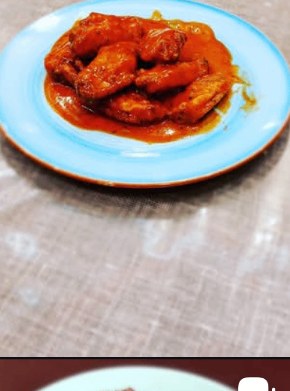 Spicy buffalo chicken wings glazed on a turquoise plate