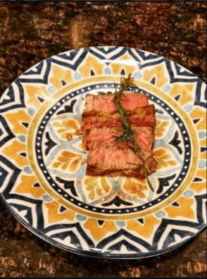 Rosemary-rubbed sliced steak on a sunburst plate